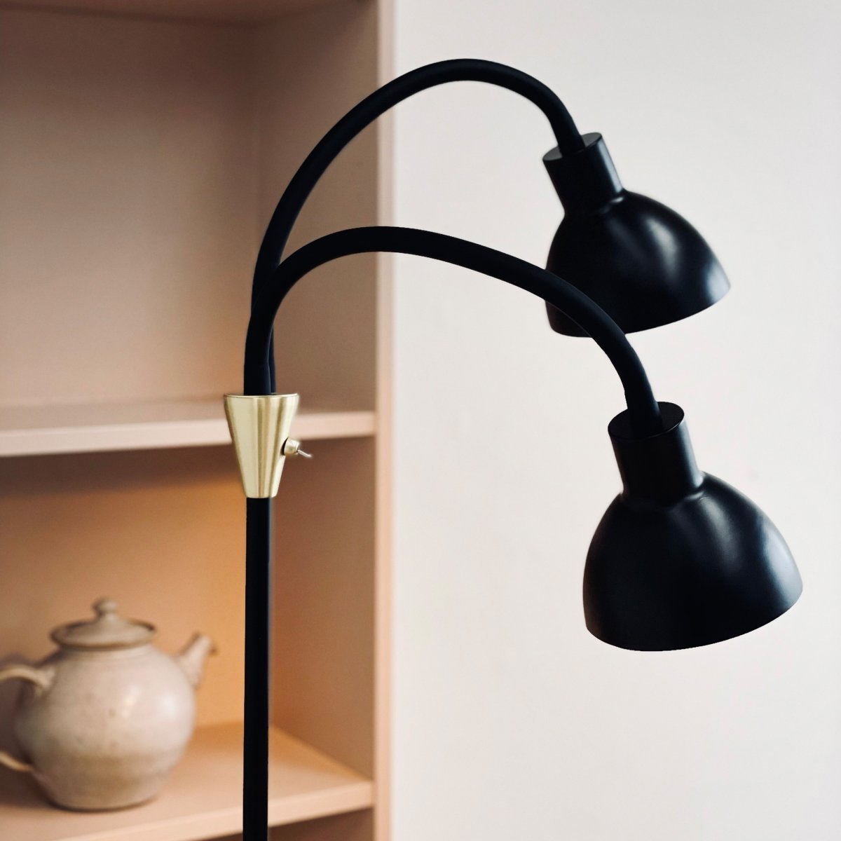 Lilje Schwarz stehlampe Von Dyberg Larsen - Lily golvlampa i svart och m&auml;ssing kombinerar modern design med flexibilitet och funktionalitet.