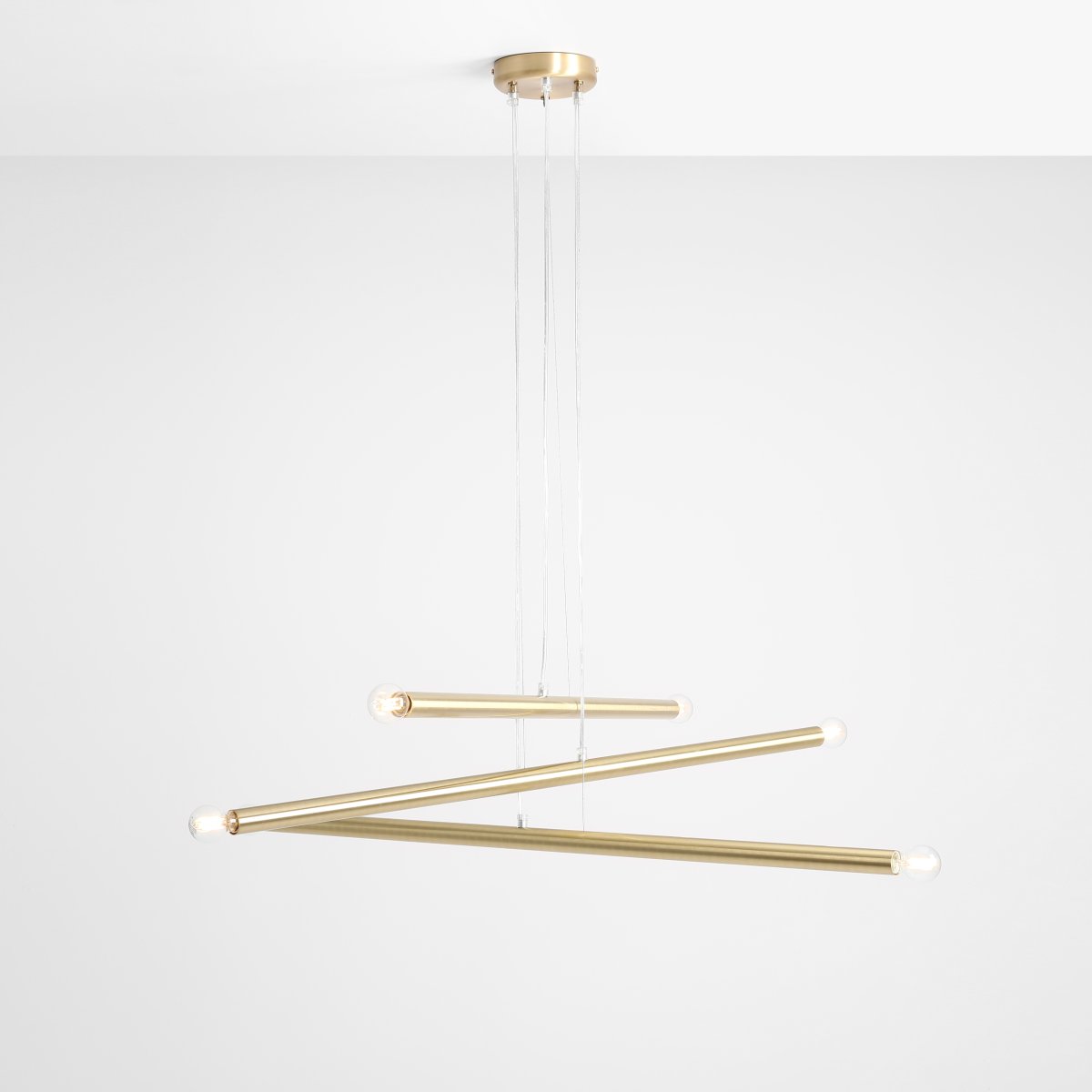 Tubo 6 100cm Messing hängelampe Von Artera - Die Leuchte besteht aus drei schmalen Metallröhren in elegantem Messing-Finish, die in unterschiedlichen Höhen und Winkeln angeordnet sind und so eine dynamische und luftige Optik erzeugen.