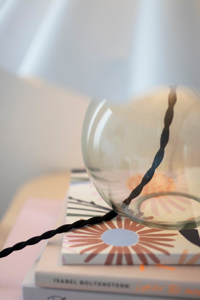 Judith 28cm Grün tischlampe Von Globen Lighting - Der Lampensockel besteht aus d&uuml;nnem, gef&auml;rbtem Gr&uuml;nglas und verf&uuml;gt &uuml;ber eine schwarze Lampenfassung aus Metall, die zum schwarzen Kabel passt.