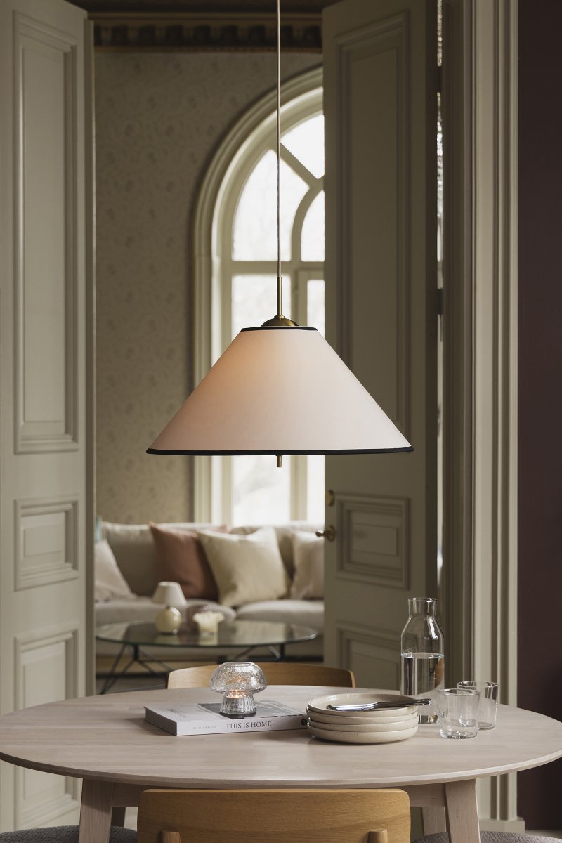 Iris Ø50 Cremeweiß hängelampe Von Globen Lighting - Die elegante Pendelleuchte Iris aus Eisen mit Messingfinish und einem handgefertigten Textilschirm aus cremefarbener Baumwolle besticht durch ihre klassische Form und die dekorativen Messingdetails, die sie beispielsweise über dem Esstisch zu einem wunderschönen Blickfang machen.