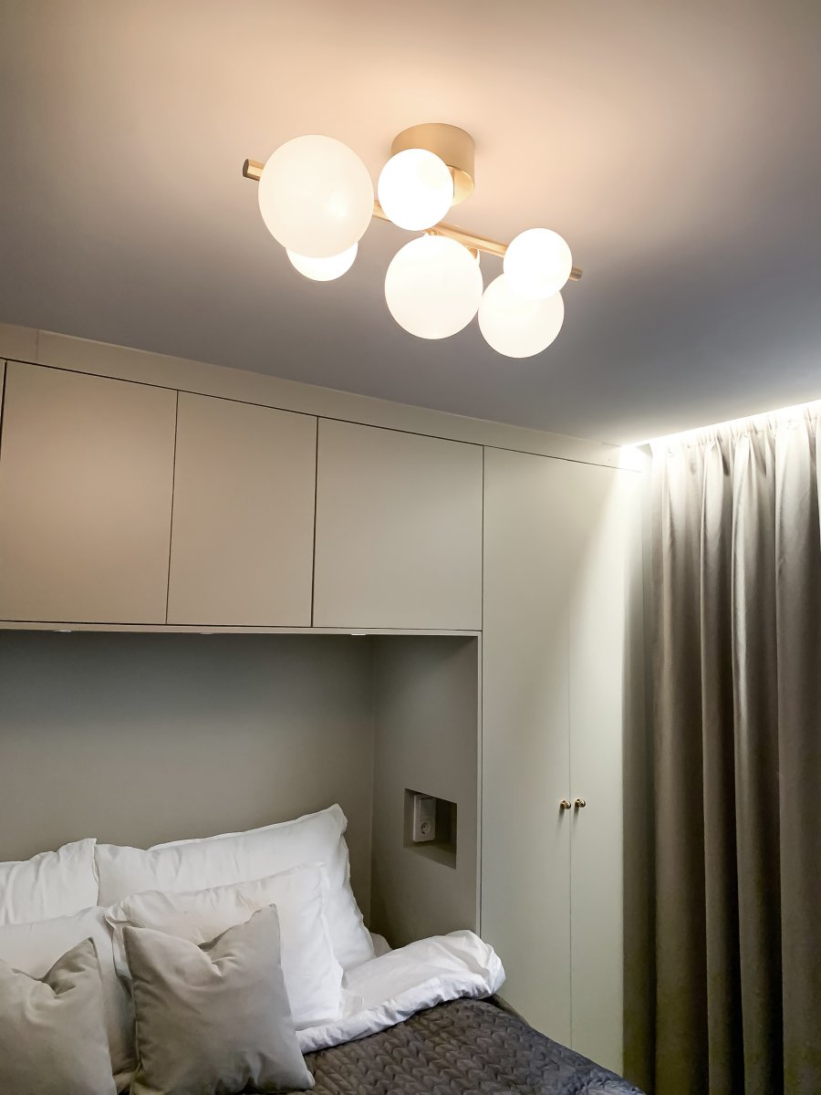 Molekyl 58cm Mattes Messing deckenleuchte Von Aneta Lighting - Trendige Deckenleuchte von Molekyl in mattiertem Messing mit 7 opalweißen Glasschirmen in verschiedenen Größen, angebracht an einer 58 cm langen Stange.