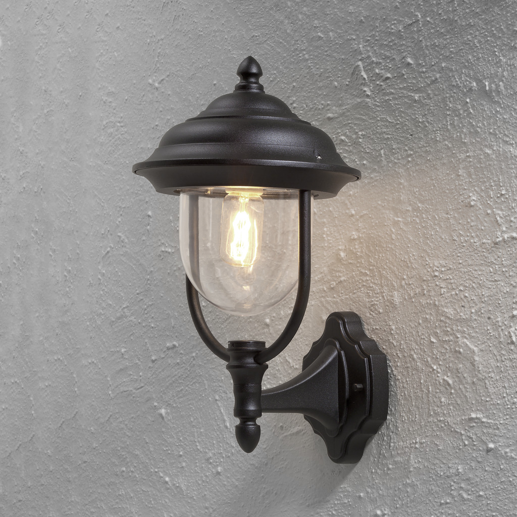Parma Schwarz außenlampe Von Konstsmide - Mit ihrer schönen Form und dem klaren Glasschirm verbreitet sie ein warmes und einladendes Licht, ideal für Eingänge und Terrassen.