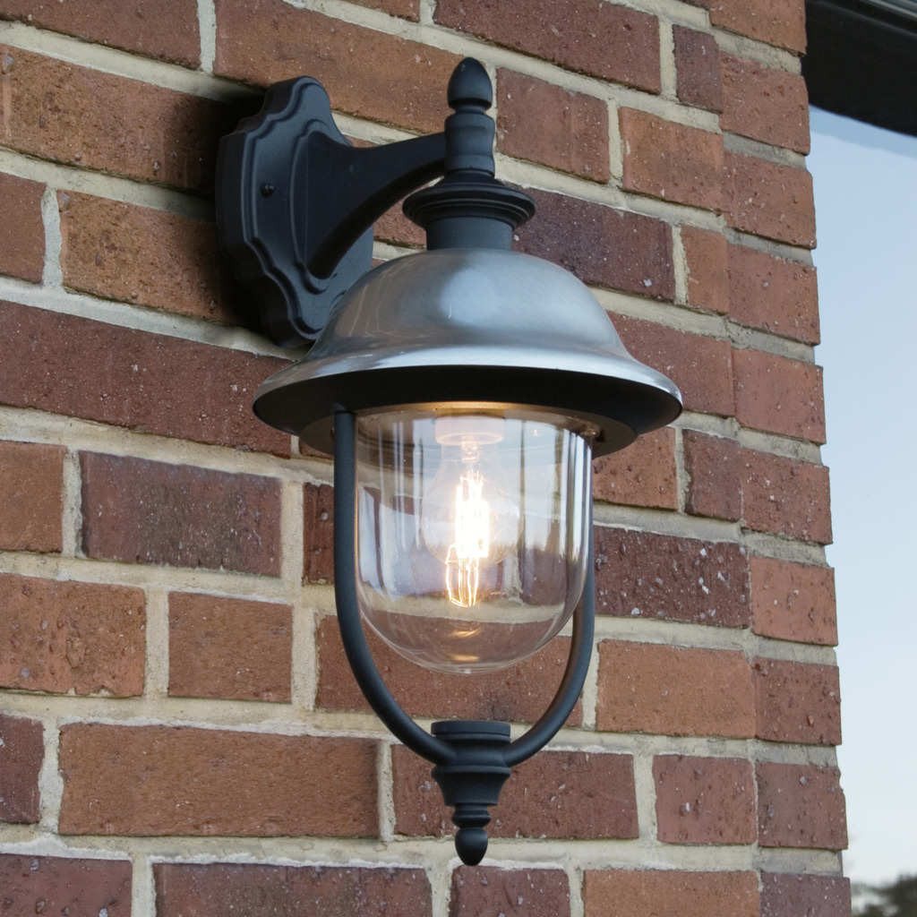 Parma Schwarz außenlampe Von Konstsmide - Mit seiner robusten schwarzen Oberfläche und dem klaren Glasschirm verbreitet es ein warmes und einladendes Licht und schafft so eine einladende Atmosphäre am Eingang oder auf der Terrasse.