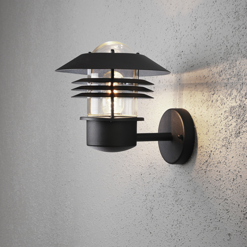 Modena Schwarz außenlampe Von Konstsmide - Mit seinem schützenden Dach und dem stilvollen Design sorgt es für ein angenehmes und gerichtetes Licht, ideal, um im Freien eine sichere und einladende Atmosphäre zu schaffen.