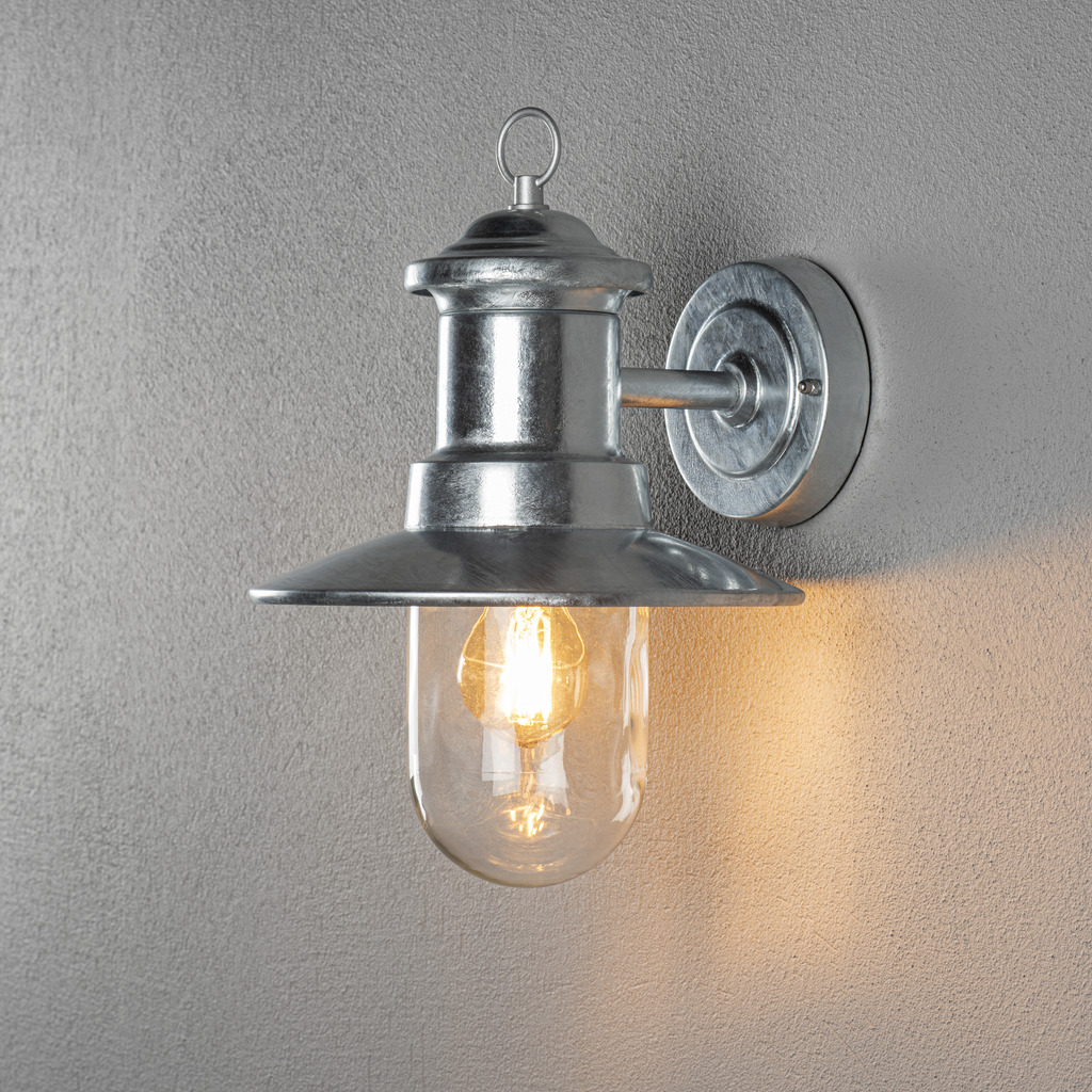 Napoli Feuerverzinkt außenlampe Von Konstsmide - Das klassische Design der Lampe mit runder Glaskuppel und breitem Schirm verbreitet ein warmes und angenehmes Licht, perfekt für die Beleuchtung von Eingängen und Terrassen.