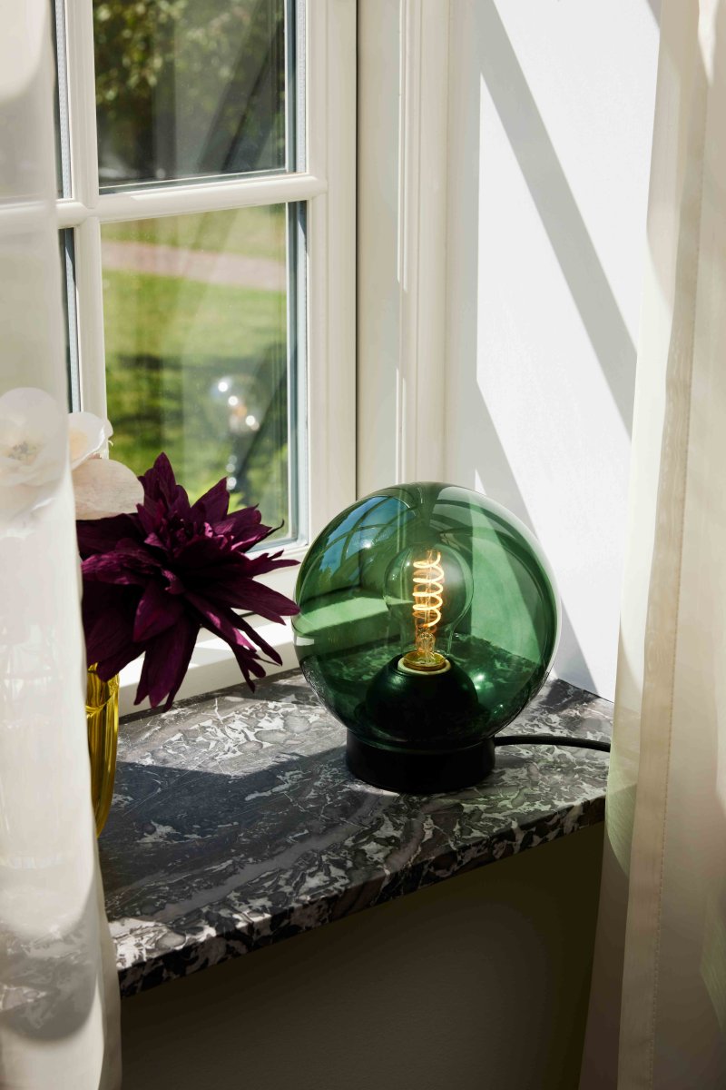 Bubbles 20cm Grün tischlampe Von Halo Design - Das grüne Glas in Kombination mit den mattschwarzen Metalldetails verleiht Eleganz und sorgt im eingeschalteten Zustand für eine schöne Lichtverteilung im Raum.