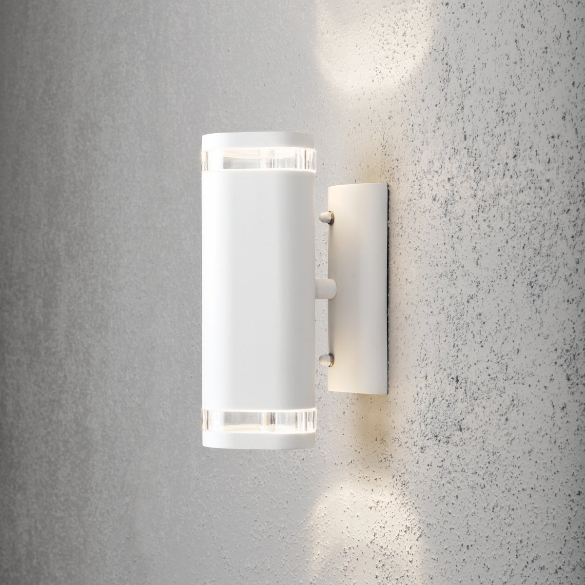 Modena II Weiß außenlampe Von Konstsmide - Das Licht wird sowohl nach oben als auch nach unten gerichtet und erzeugt ein dekoratives und wirkungsvolles Lichtbild, das die Fassade aufwertet und dem Garten eine einladende Atmosph&auml;re verleiht.