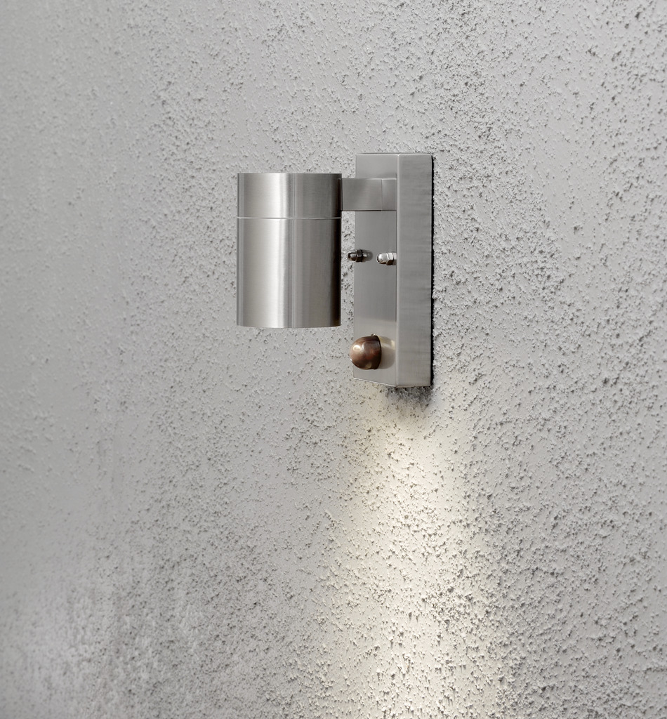 Modena Silber außenlampe Von Konstsmide - Das stilvolle und moderne Design der Lampe fügt sich in jede Fassade ein und schaltet sich automatisch ein, wenn sie eine Bewegung erkennt, was für zusätzliche Sicherheit in Eingängen und Gehwegen sorgt.