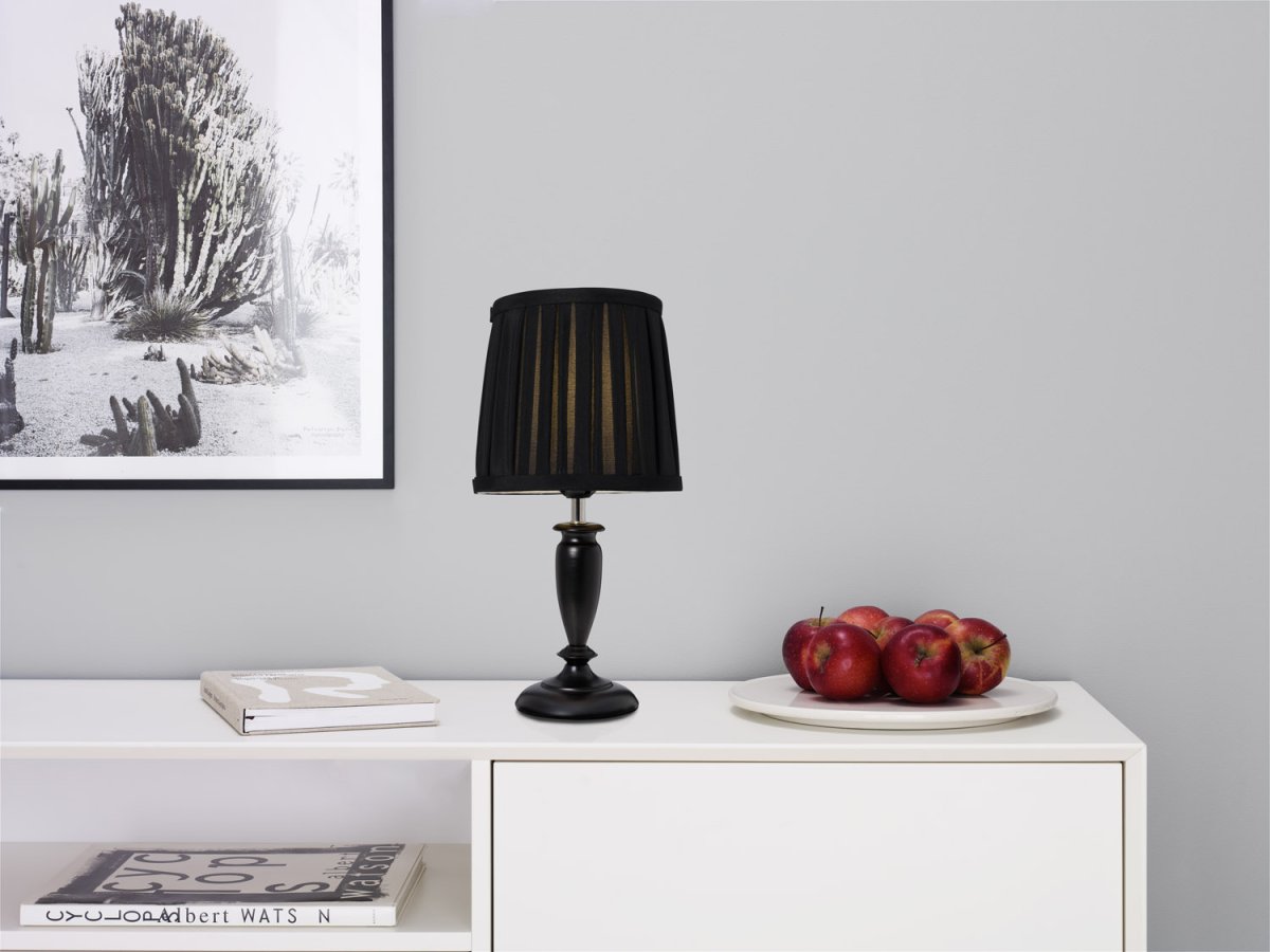 Ines 34cm Schwarz tischlampe Von Cottex - Der schöne Metallsockel in Kombination mit dem plissierten Textilschirm schafft eine warme und einladende Atmosphäre.