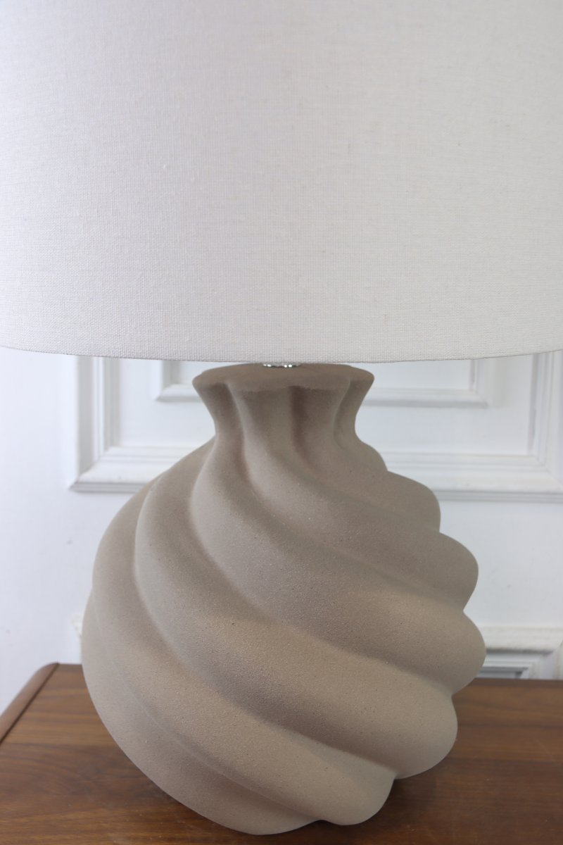 Vindel 52cm Sand tischlampe Von Lampan - Der Keramikfu&szlig; besticht durch seine sandfarbene, strukturierte Oberfl&auml;che und ein sanft geschwungenes Design, das ihm eine lebendige und skulpturale Ausstrahlung verleiht.
