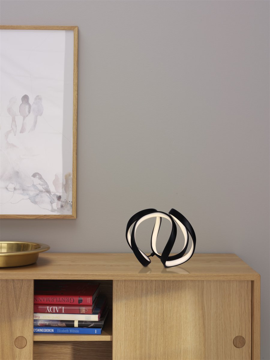 Wave 18cm Schwarz tischlampe Von Cottex - Wave bordslampa i metall och silikon &auml;r en modern och elegant belysningsl&ouml;sning som ger ditt rum en unik och stilfull k&auml;nsla.
