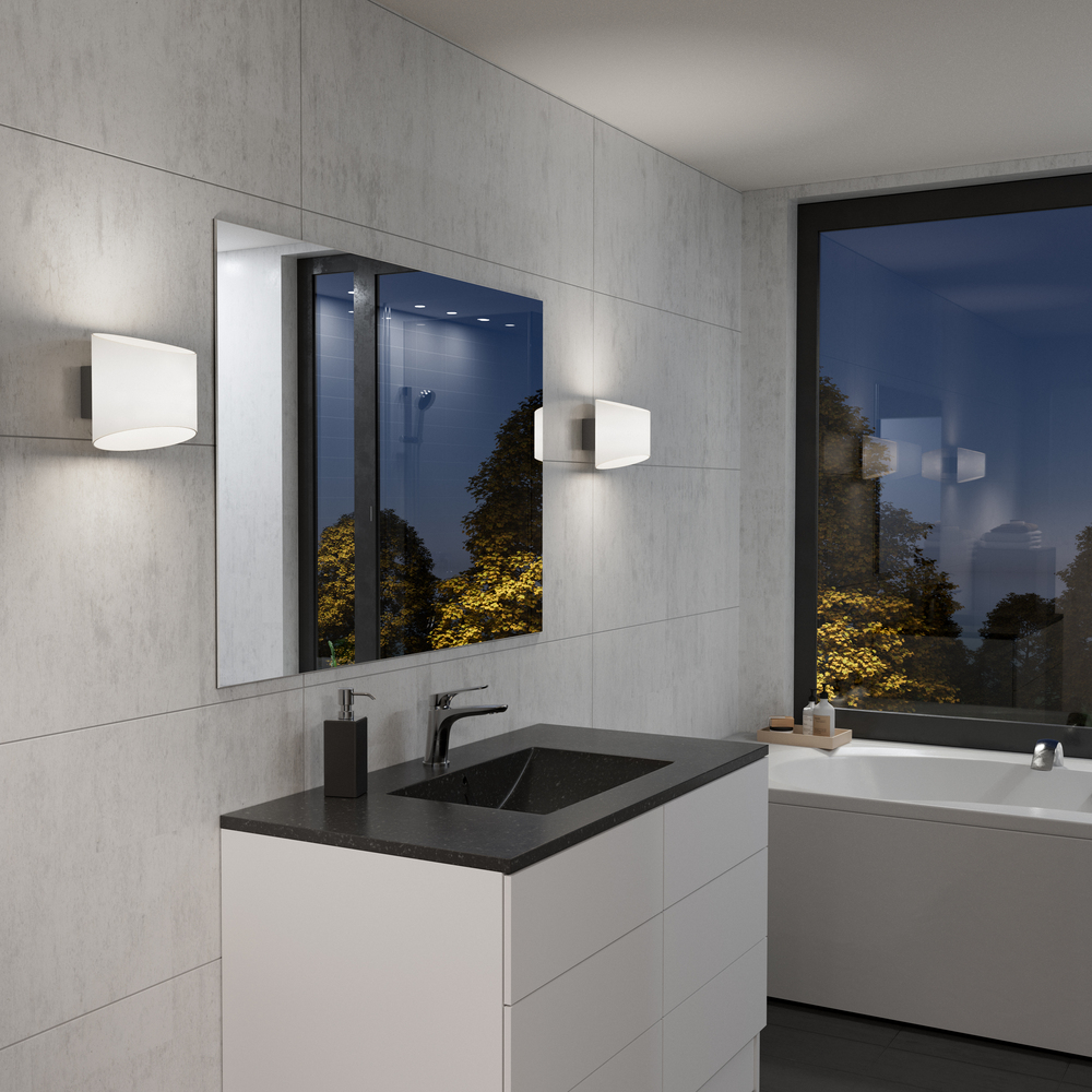 Evoke Oval Anthrazit/Opal wandlampe Von Herstal - Den smarta konstruktionen med b&aring;de upp- och nerljus g&ouml;r den till ett utm&auml;rkt val f&ouml;r att belysa din hall, vardagsrum eller sovrum p&aring; ett subtilt men effektfullt s&auml;tt.