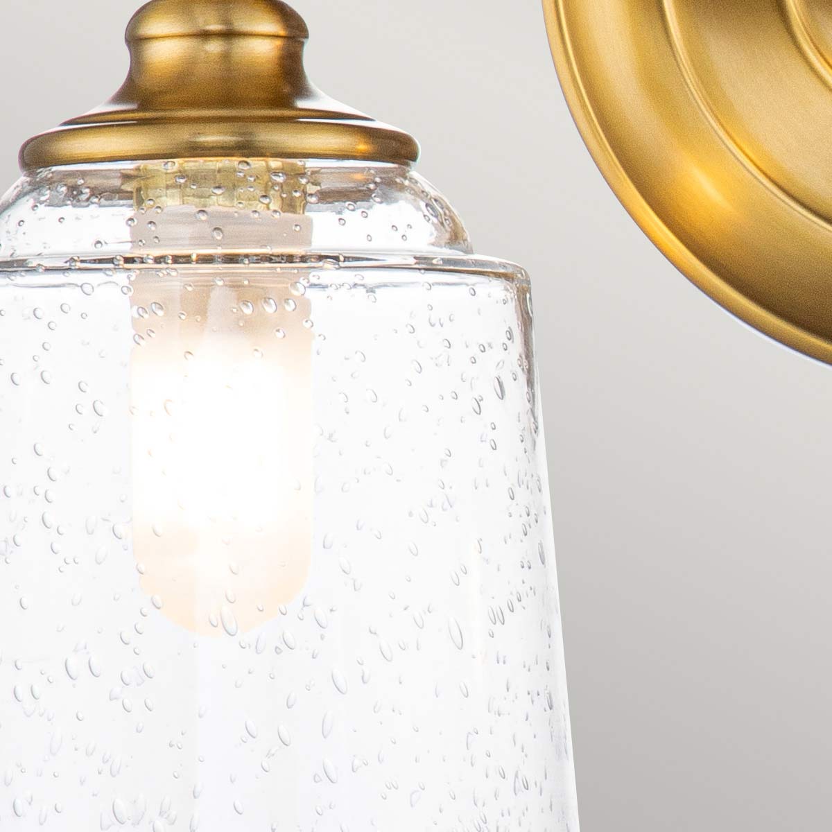 Huguenot Lake 33cm Messing badezimmerlampe Von Elstead Lighting - Die eleganten runden Details und die handgeschliffenen Fassungen vermitteln ein Gefühl traditioneller Handwerkskunst, während das klare, strukturierte Glas ein weiches und einladendes Licht erzeugt.