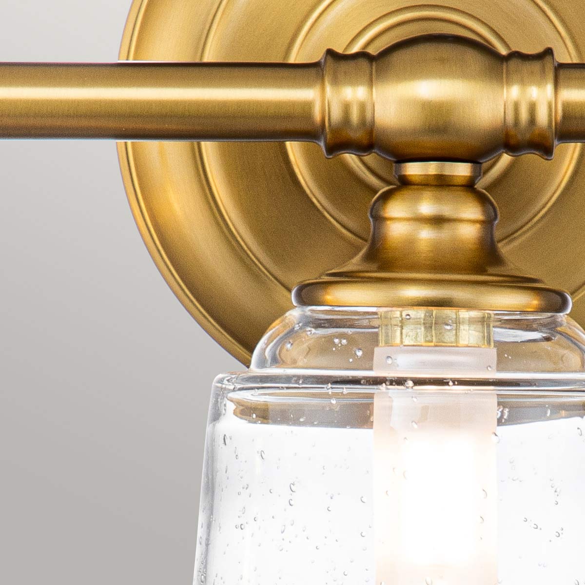 Huguenot Lake 53cm Messing badezimmerlampe Von Elstead Lighting - Die eleganten runden Details und die handgeschliffenen Fassungen vermitteln ein Gefühl traditioneller Handwerkskunst, während das klare, strukturierte Glas ein weiches und einladendes Licht erzeugt.