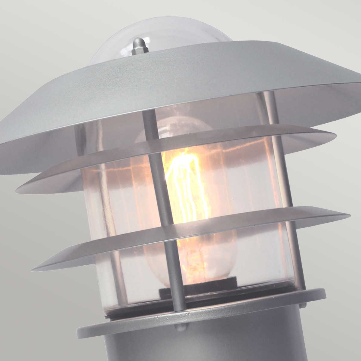 Helsingor 30cm Silber Von Elstead Lighting - Tillverkad av rostfritt st&aring;l i silverfinish och glas, erbjuder den en slitstark och v&auml;derbest&auml;ndig konstruktion som &auml;r perfekt f&ouml;r entr&eacute;er, tr&auml;dg&aring;rdsg&aring;ngar och uteplatser.