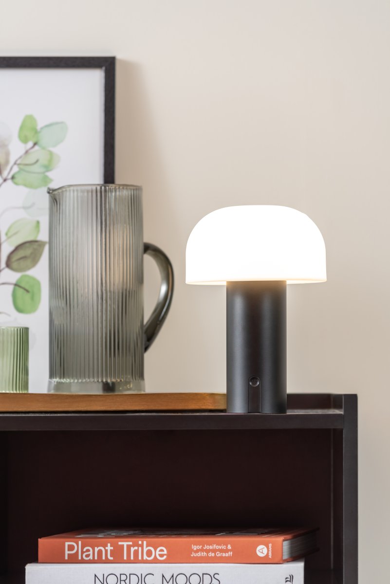 Luca LED 22cm Schwarz tragbare Von Leitmotiv - Sie besteht aus Metall mit einer mattschwarzen Oberfläche und verfügt über einen milchig-weißen Kunststoffschirm, der ein sanftes und angenehmes Licht verbreitet.