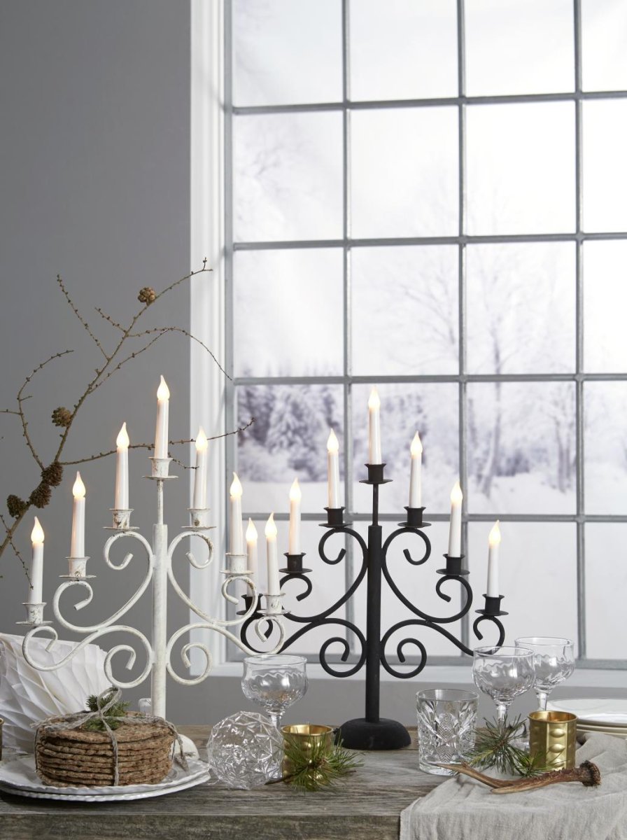 Smide 7 Weiß Von Pixie Design - Ein eleganter und rustikaler Kerzenst&auml;nder aus Schmiedeeisen mit sieben Armen, in einer stilvollen Kombination aus Wei&szlig; und Antikgold.