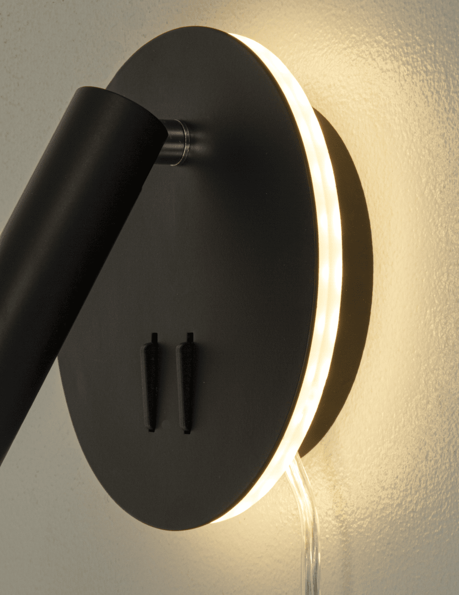 Ace Schwarz leselampe Von Aneta Lighting - Die Lampe verf&uuml;gt &uuml;ber ein Leselicht mit verstellbarem Kopf sowie eine indirekte Beleuchtung, die die Wand um die Lampe herum beleuchtet.